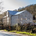 Image shows Rock Mill apartments from outside in the early winter sunlight