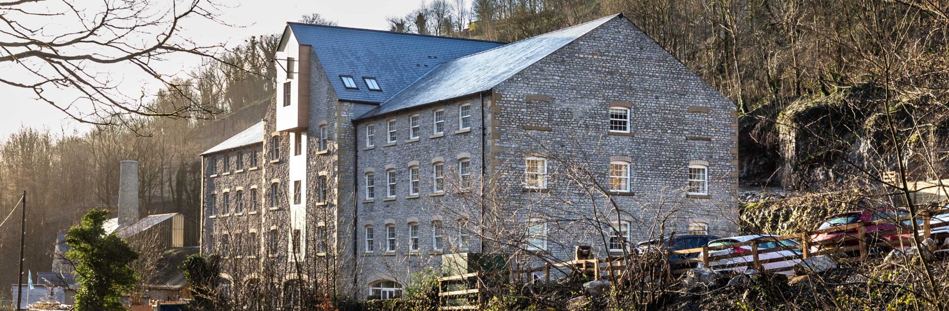 Image shows Rock Mill apartments from outside in the early winter sunlight