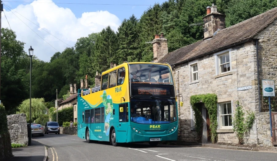 Peak sightseer bus driving through Ashford in the Water