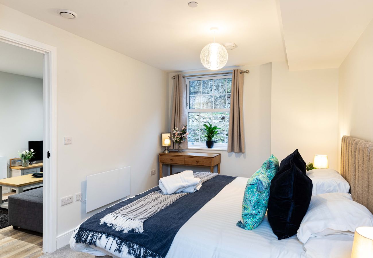 Image of the bedroom with soft lighting and desk space inside apartment 27 at Rock mill