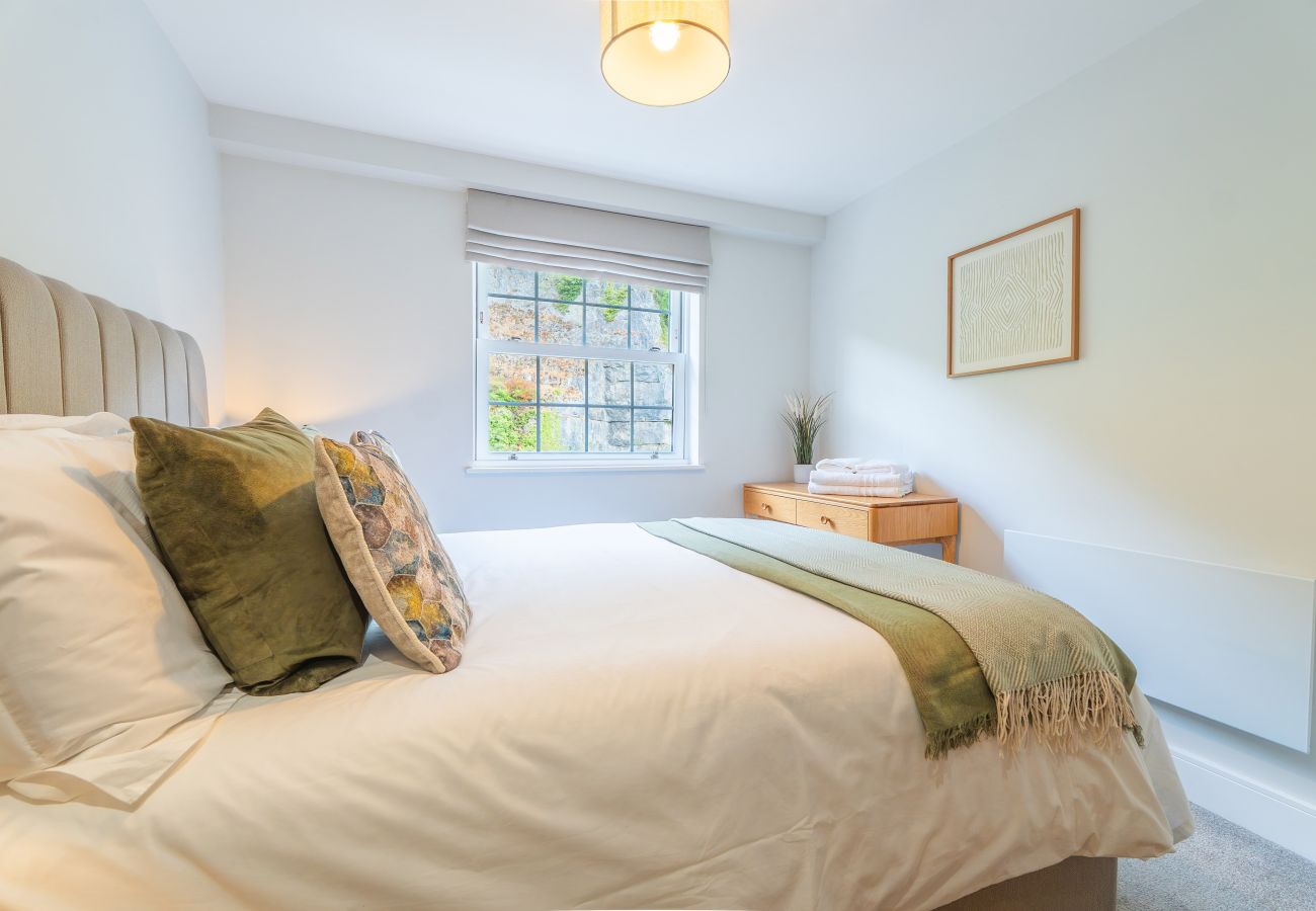 Image shows light and spacious bedroom with fixed king size double bed